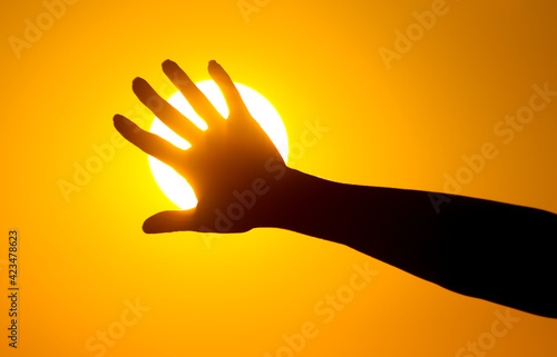 The girl holds the sun with her hands