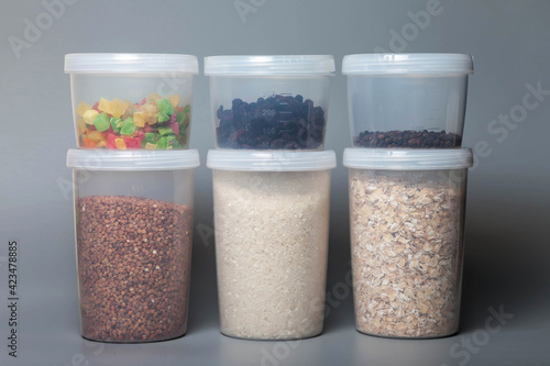 Measuring cans of 1000 and 400 cubic measure for storing bulk products with food on gray background. Transparent plastic container for storing food and bulk product. Cereals and bulk products in jars