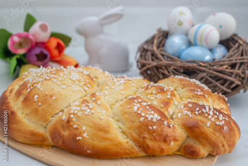 Sweet home made braided yeast bun for easter on a table photo