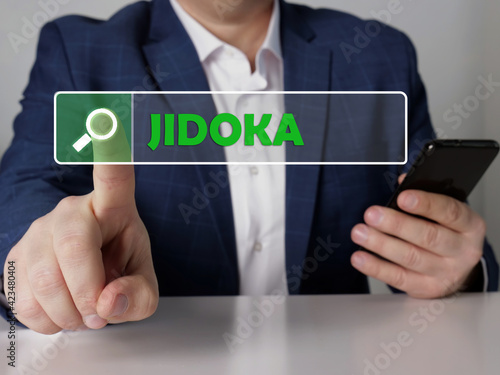  JIDOKA text in search bar. Broker looking for something at cellphone. JIDOKA concept. photo