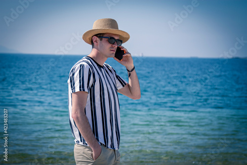 relaxed man walking on the beach talking on the phone © tetxu