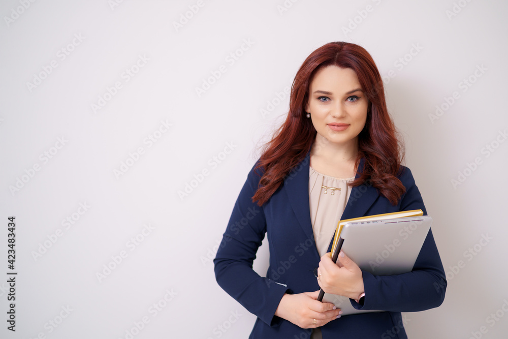 Beautiful modern woman having an laptop in hands, leaning on a white wall Beautiful modern woman having an laptop in hands, leaning on a white wall