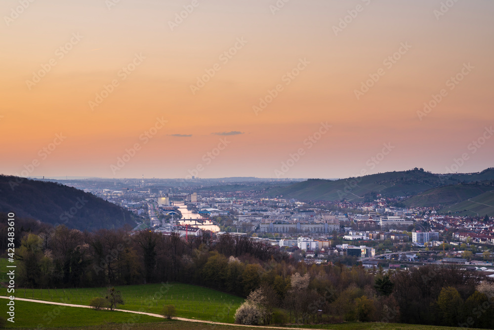 Germany, Orange glowing sunset sky above the houses and neckar river of stuttgart city at dawning from above