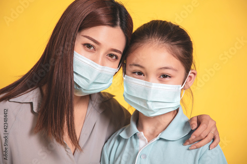  mother hugs little daughter in protective medical masks during Covid-19 pandemics