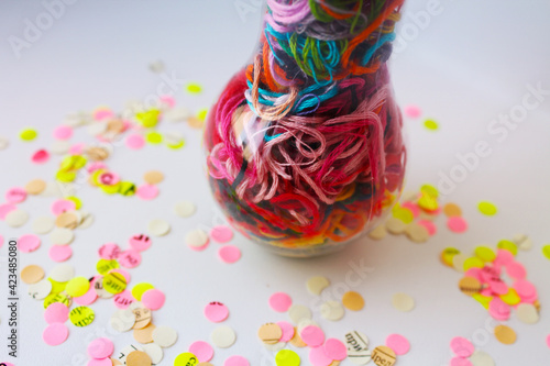 Handmade light bulbs with multi-colored floss threads on a white background  creative idea for banner