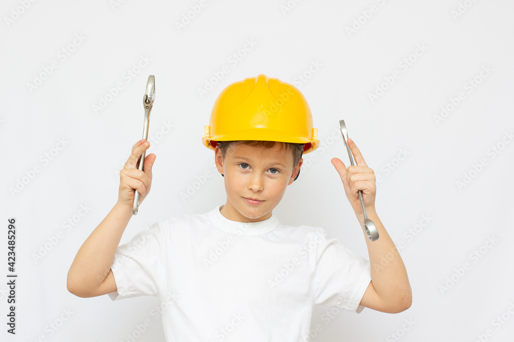 Little Boy using tools at home little builder in the helmet and saw the work of thinking about the future Little Boy using tools at home little builder in the helmet and saw the work of thinking about the future