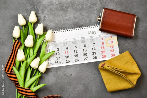 9 may. George ribbon, calendar, flowers tulips, flask and military cap on gray background. traditional symbol of Victory Day 1945. Holiday Victory Day. Greeting card. Flat lay.