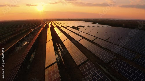 Golden Sun Light Touches Solar Panels. Ecology solar Power Station. Ecology concept. Flying above Panels in the Fields. Green energy at sunset in Germany. Electrical innovation