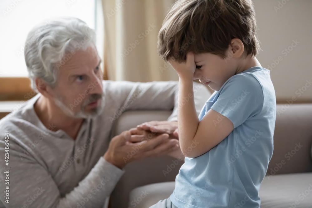 Loving mature grandfather hug hold hand of unhappy sad little 8s grandson feeling hurt offended. Caring older Caucasian granddad make peace comfort caress upset small preschooler grandchild. Loving mature grandfather hug hold hand of unhappy sad little 8s grandson feeling hurt offended. Caring older Caucasian granddad make peace comfort caress upset small preschooler grandchild.