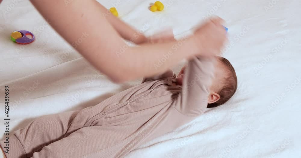 Gymnastics baby. woman doing exercises with child for its development. massage a small newborn baby, does exercises on the arms. Concept of parenthood, childhood, maternity, motherhood Gymnastics baby. woman doing exercises with child for its development. massage a small newborn baby, does exercises on the arms. Concept of parenthood, childhood, maternity, motherhood
