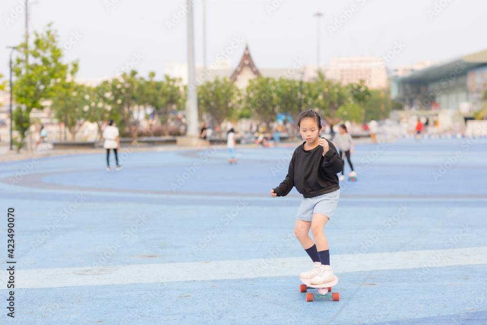 Asian girl playing surfskate in the park. sport and recreation concept.