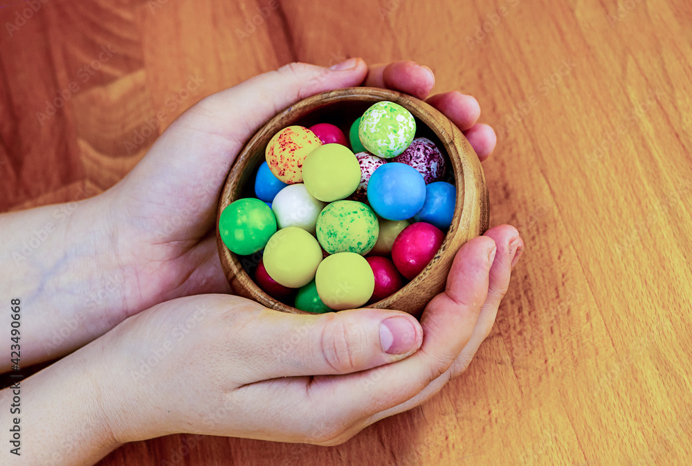 colorful candy green, yellow, red and blue in bowl on hand festive decor colorful candy green, yellow, red and blue in bowl on hand festive decor