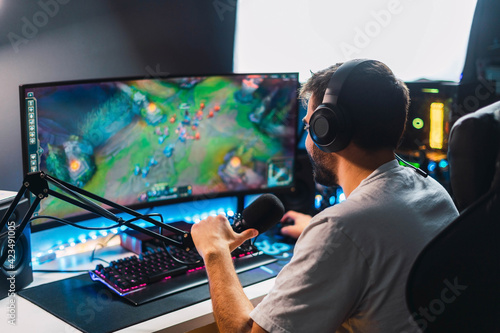 Young gamer playing video games online while broadcasting on social media - Working live streaming on internet platforms	