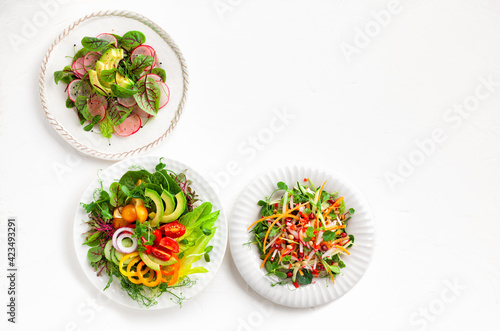Various healthy salads of fresh vegetables,fruits and microgreens on table. Clean eating food. Top view. Concept taste of home meal.