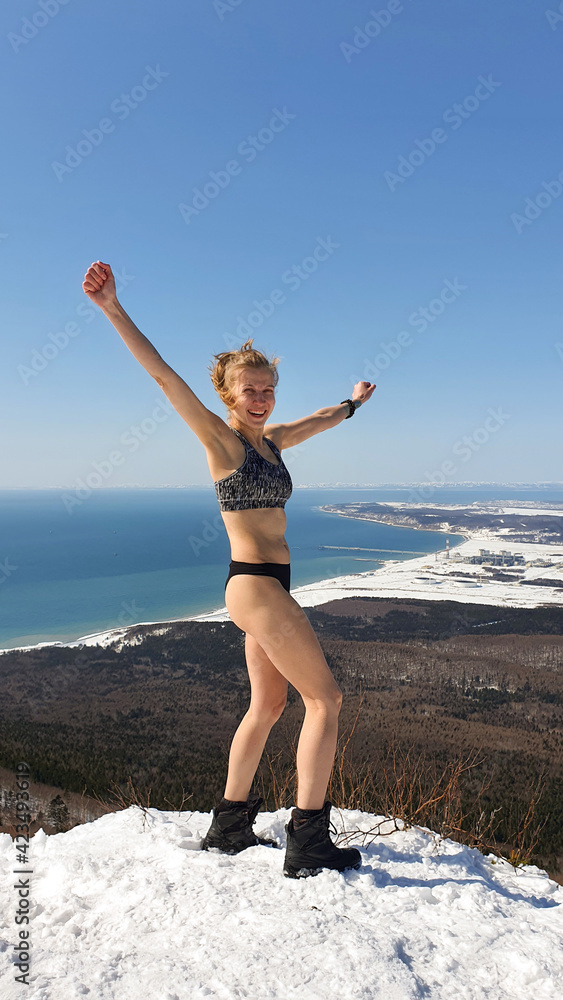 Sports girl on the top of the mountain. Trekking in the mountains in winter