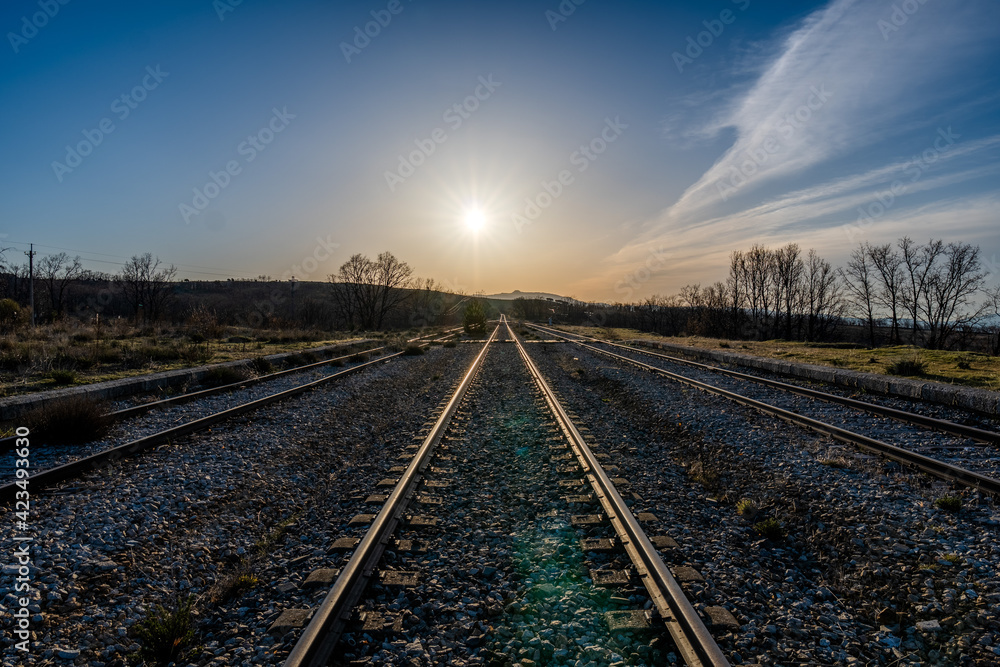 railway in the countryside with the sun and the blue sky railway in the countryside with the sun and the blue sky