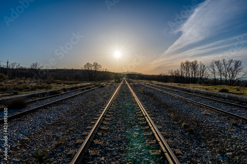 railway in the countryside with the sun and the blue sky