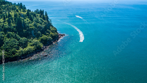 Boats running along a beautiful coastline. Coromandel, New Zealand.