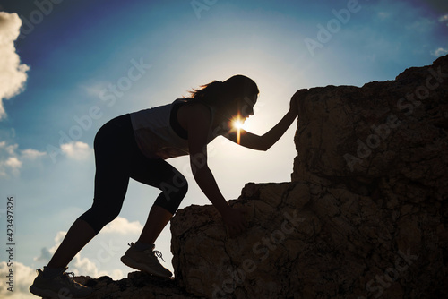 Silhouette hiking woman climb to montain peak