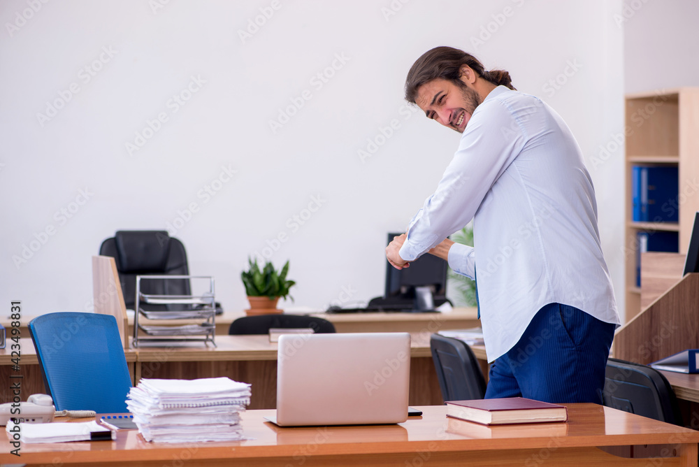 Young male furious employee holding baseball bat in the office Young male furious employee holding baseball bat in the office