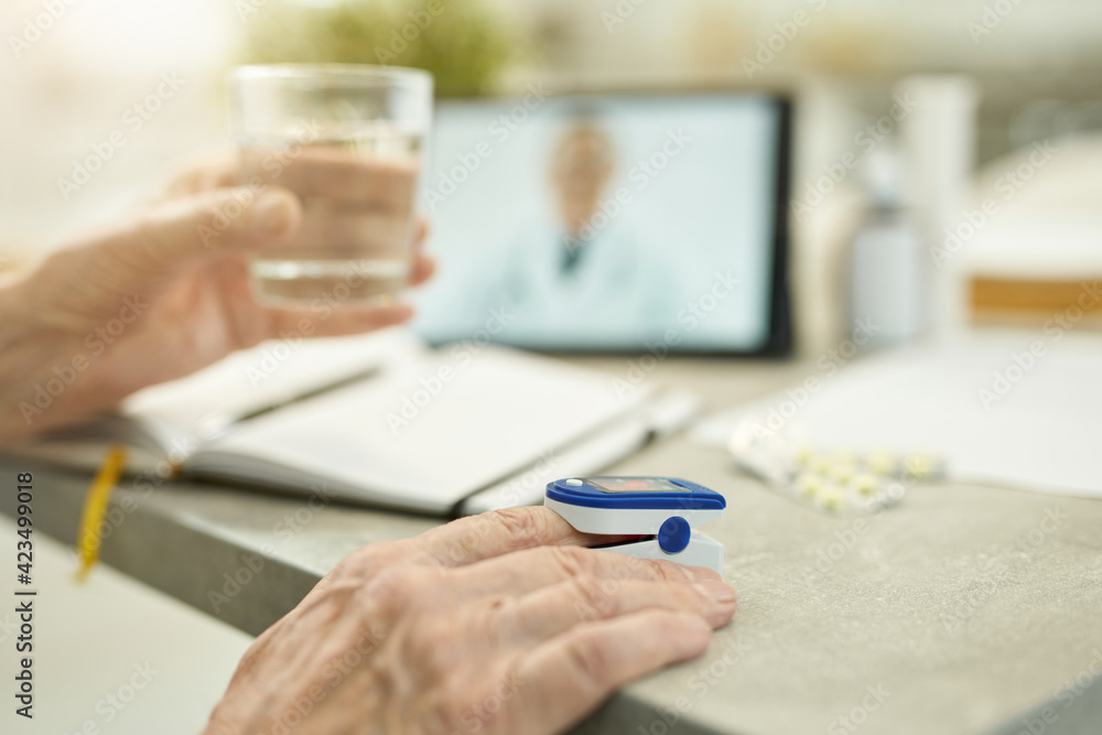 Elderly person taking his vitals for online medical consultation