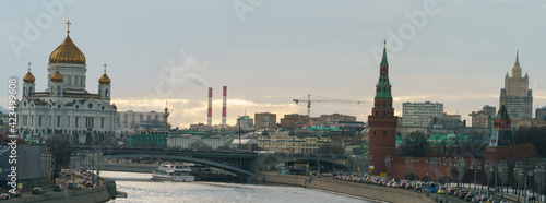 Moscow cityscape in the spring day. Red Kremlin Towers, Cathedral of Christ the Saviour, Moskva River, Bolshoy Kamenny Bridge, traffic at the embankment. Stalinist architecture in the distance