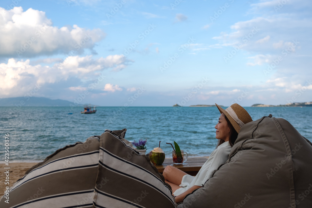 A beautiful asian woman enjoy sitting and relaxing on bean bag on the beach A beautiful asian woman enjoy sitting and relaxing on bean bag on the beach