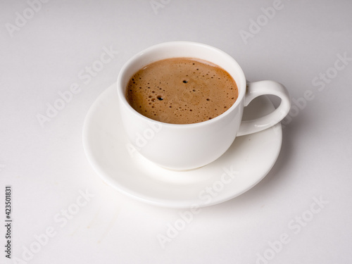 Coffee with milk in a white cup on a white background. Studio photography
