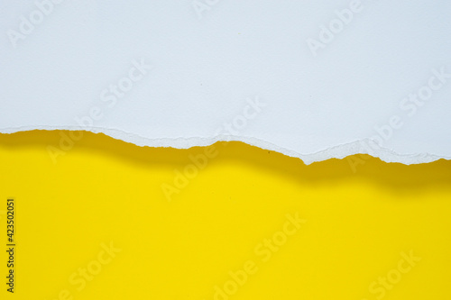abstract background with ripped white paper on yellow paper and soft shadow.