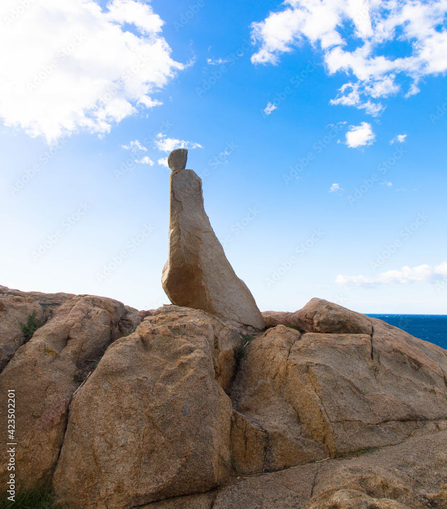Stone stacks on a rock against a blue sky overlooking the old town of Calvi, Corsica Tourism and vacation concept