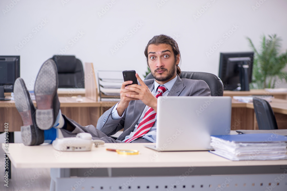 Fototapeta premium Young male employee working in the office