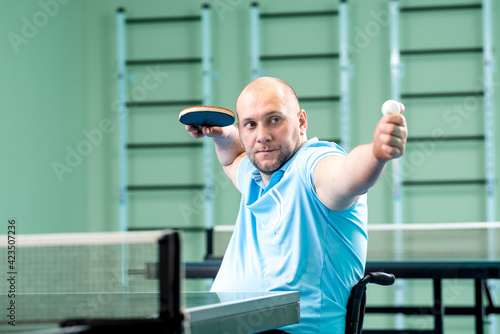 Adult disabled man in a wheelchair training before play at table tennis © romaset