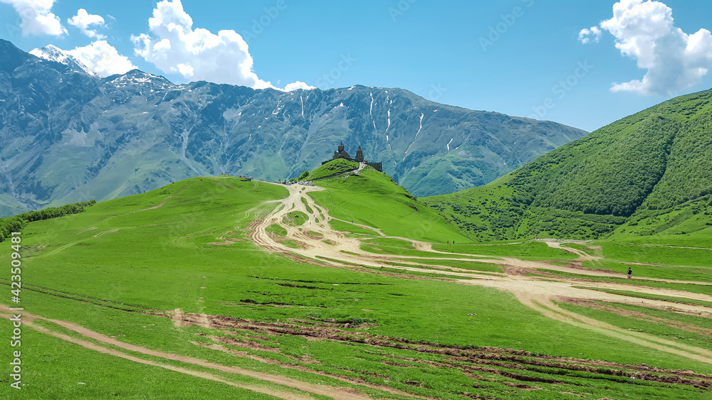 Panoramic view of the Caucasus Mountains and the Trinity Church in Gergeti. Georgia