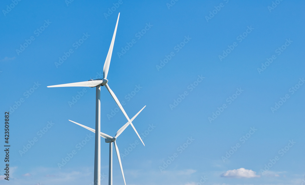 Un par de molinos de viento produciendo energía eólica verde Un par de molinos de viento produciendo energía eólica verde