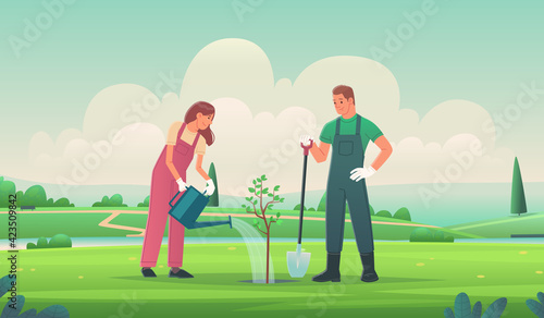 Happy couple is planting a tree. A man and a woman are gardening. Volunteering and caring for the environment