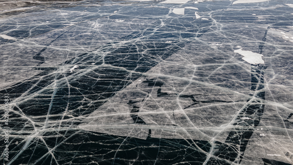Deep Blue Cracked Ice. Top Aerial View. Frozen Texture of Baikal Lake in Russia