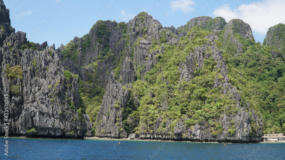 Green lush karst mountains rising out of the ocean on Palawan Island near El Nido, Philippines Green lush karst mountains rising out of the ocean on Palawan Island near El Nido, Philippines