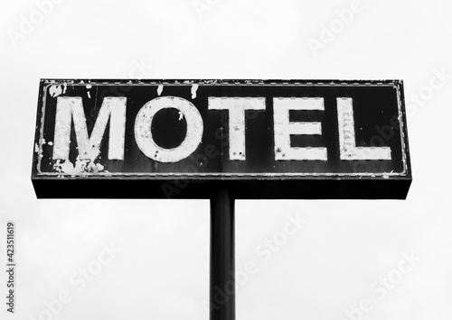 Black and white photo of Large dilapidated and peeling motel sign in the South