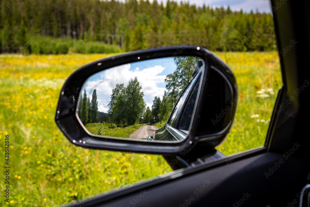 Auto Rückspiegel bei einem road Trip, Landschaft im Hintergrund