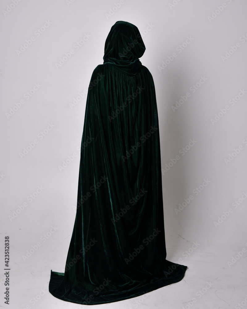 full length portrait of red haired girl wearing celtic, green medieval gown with fantasy velvet cloak. Standing pose isolated against a studio background. full length portrait of red haired girl wearing celtic, green medieval gown with fantasy velvet cloak. Standing pose isolated against a studio background.