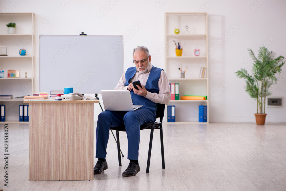 Old male designer working in the office Old male designer working in the office