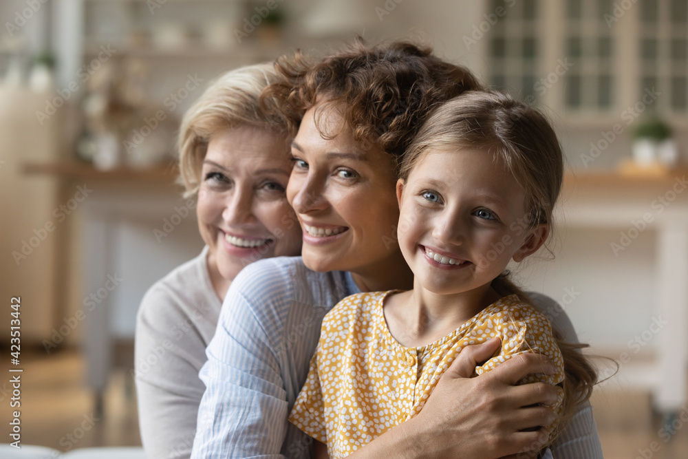Overjoyed little girl with young mother and mature grandmother hug ...