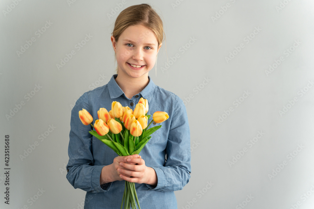 Little girl holding a bouquet of yellow tulips on a white background. Teen girl on a white background. Little girl holding a bouquet of yellow tulips on a white background. Teen girl on a white background.