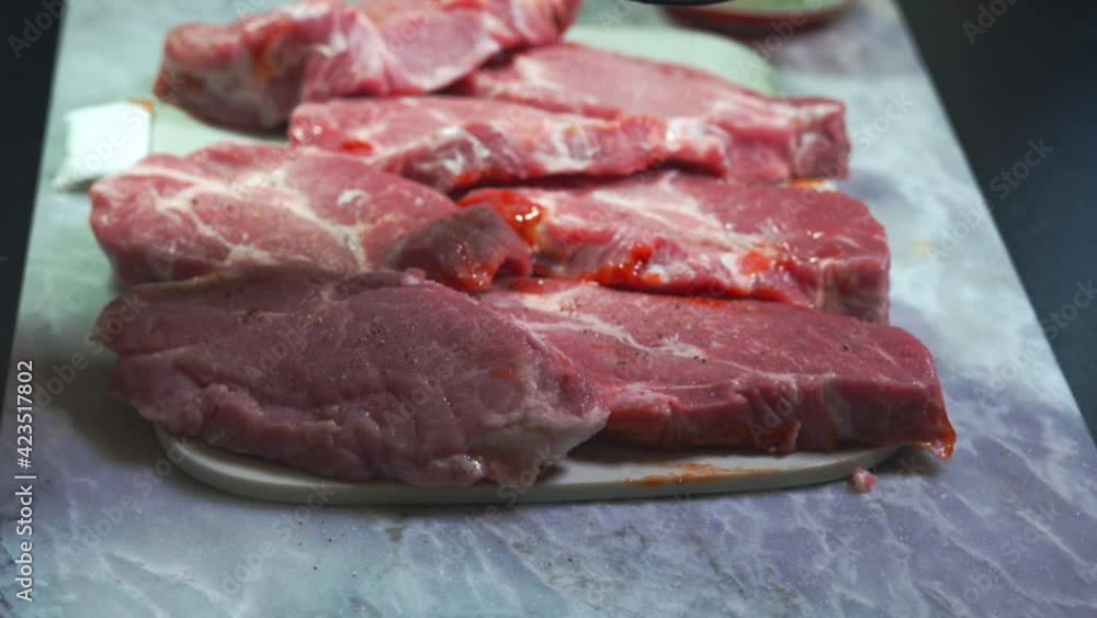 Close up view of steak being brushed with bbq marinade. Food and health concept. Close up view of steak being brushed with bbq marinade. Food and health concept.