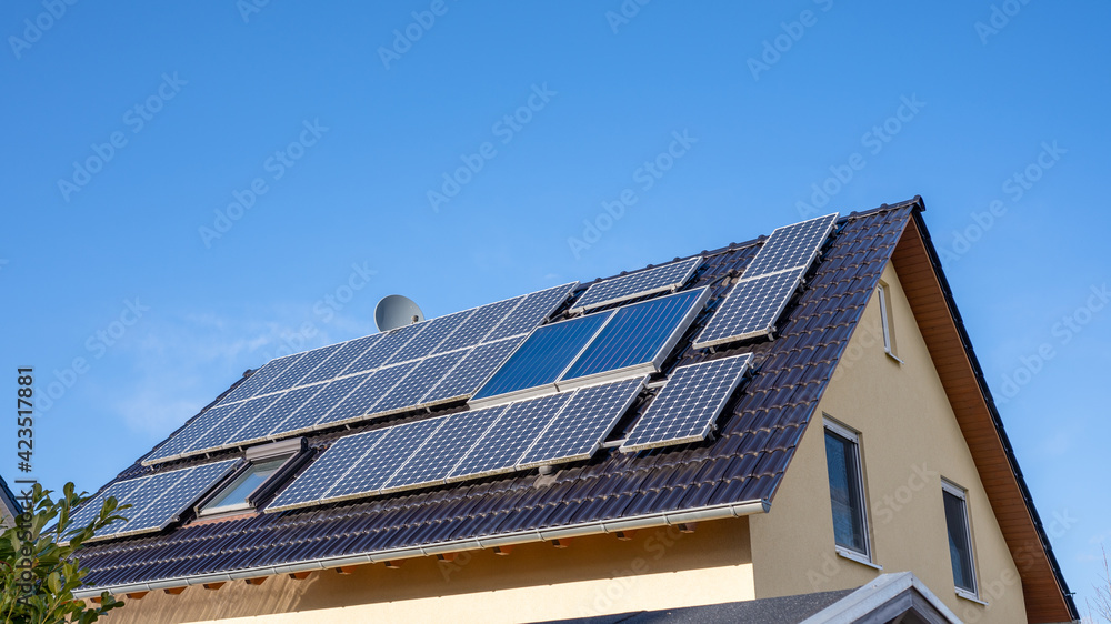 Dach eines Einfamilienhaus mit vielen Solarzellen Dach eines Einfamilienhaus mit vielen Solarzellen