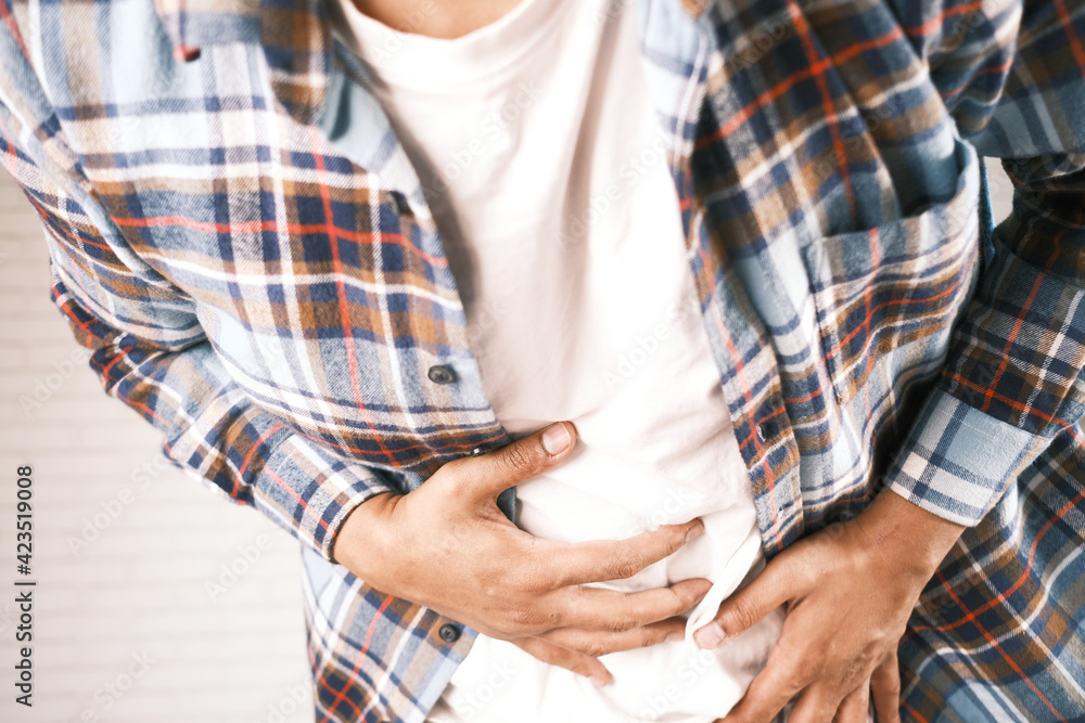 young man suffering stomach pain close up.