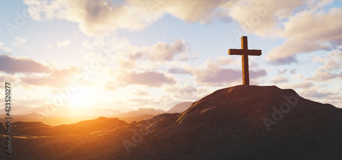 Fotografering Cross on mountain peak at sunset christian religion
