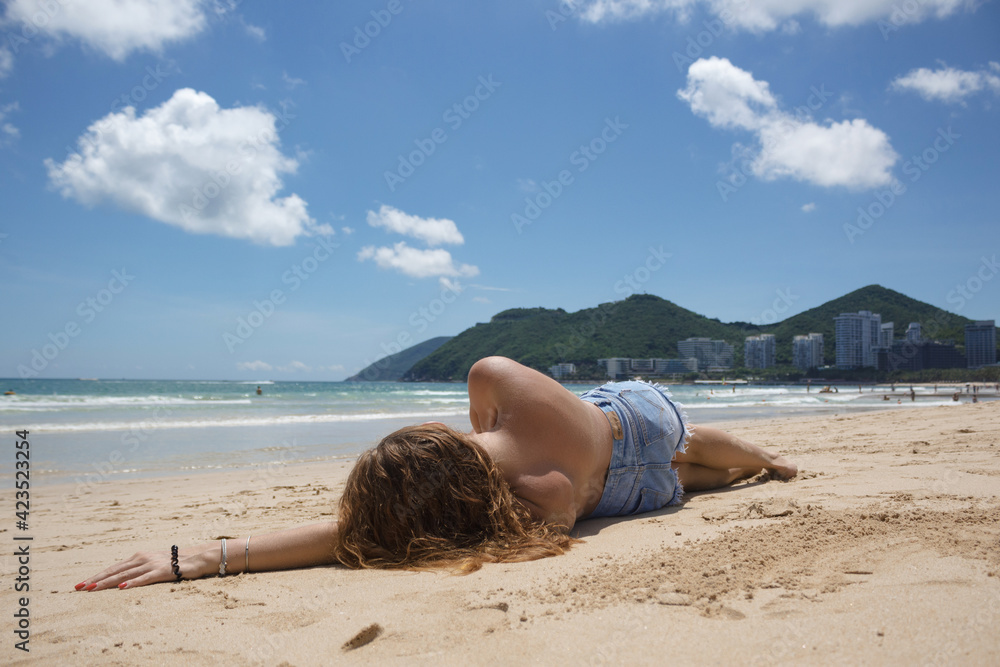 Beautiful Girl in a swimsuit on the beach. Tropical Landscape
