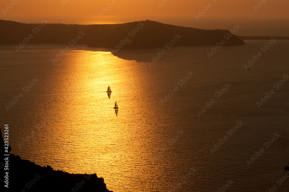 sunset on the caldera santorini with boat sailing back to the post