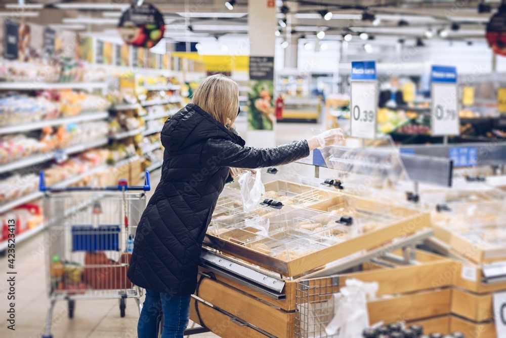Woman on shopping. She choosing bakery products in supermarket.